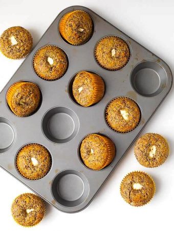 Orange Chocolate Cream Cheese Muffins in a muffin pan on a white background