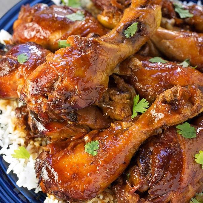 Close up of  Sticky Chicken Drumsticks with rice on a blue plate