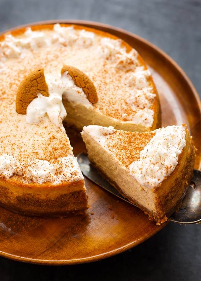 Eggnog Cheesecake on a wooden plate with a slice being removed