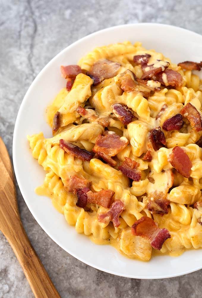 Chicken Bacon Ranch Pasta in white bowl next to wooden spoon