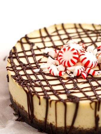 Instant Pot White Chocolate Peppermint Cheesecake garnished with peppermint candies on white background