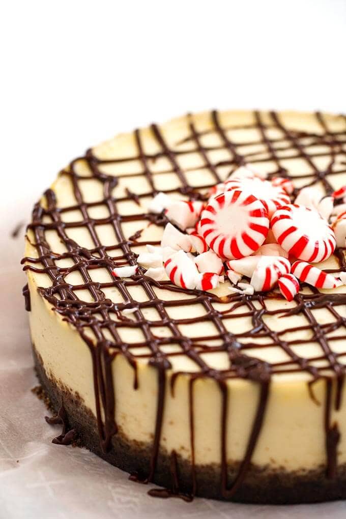 White Chocolate Peppermint Cheesecake garnished with peppermint candies on white background