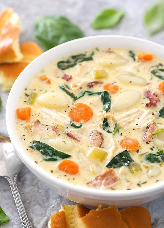 Creamy Chicken Gnocchi Soup in a white bowl next to a silver spoon