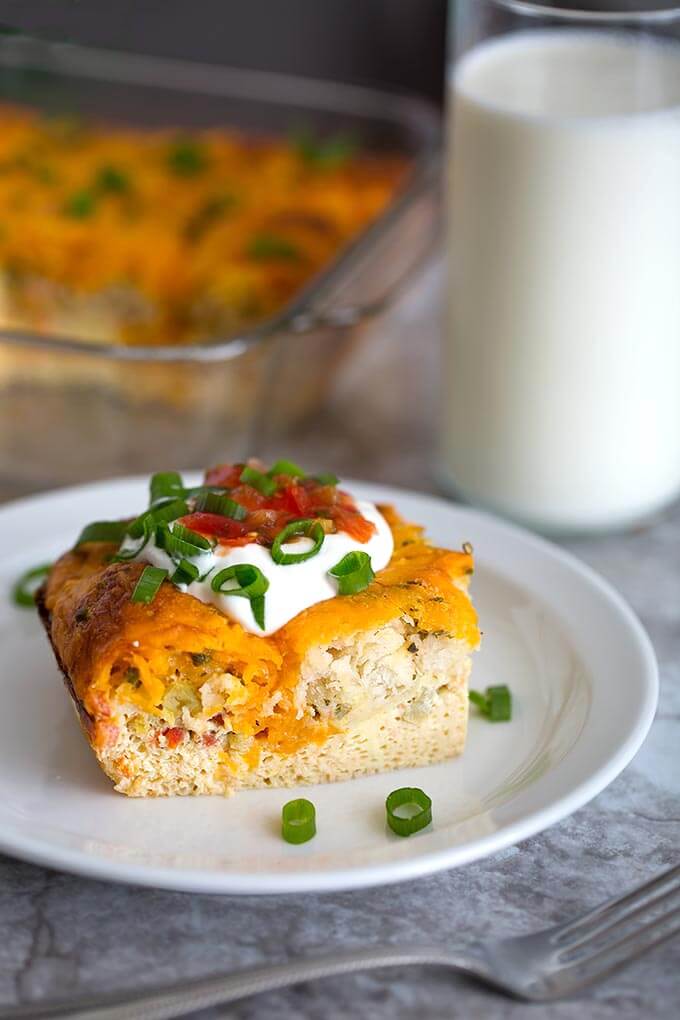 Breakfast Egg Bake slice on white plate next to glass of milk and silver fork