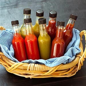 Basket containing eight homemade hot sauce bottles