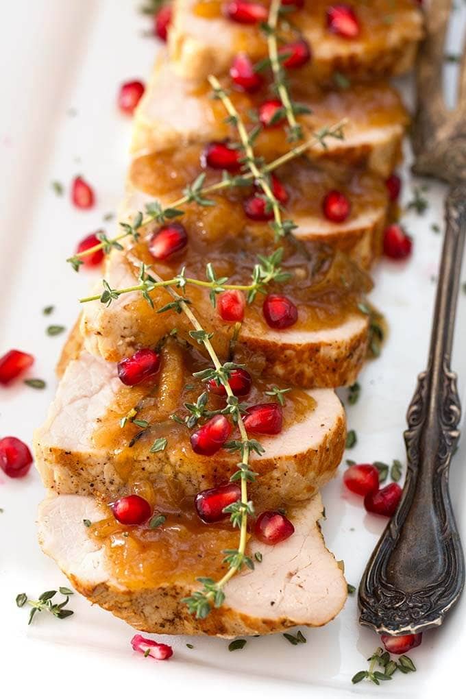 Sliced Balsamic Apple Pork Tenderloin on a white plate with silver fork