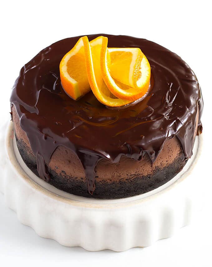 Instant Pot Chocolate Orange Cheesecake on a white serving dish garnished with sliced orange