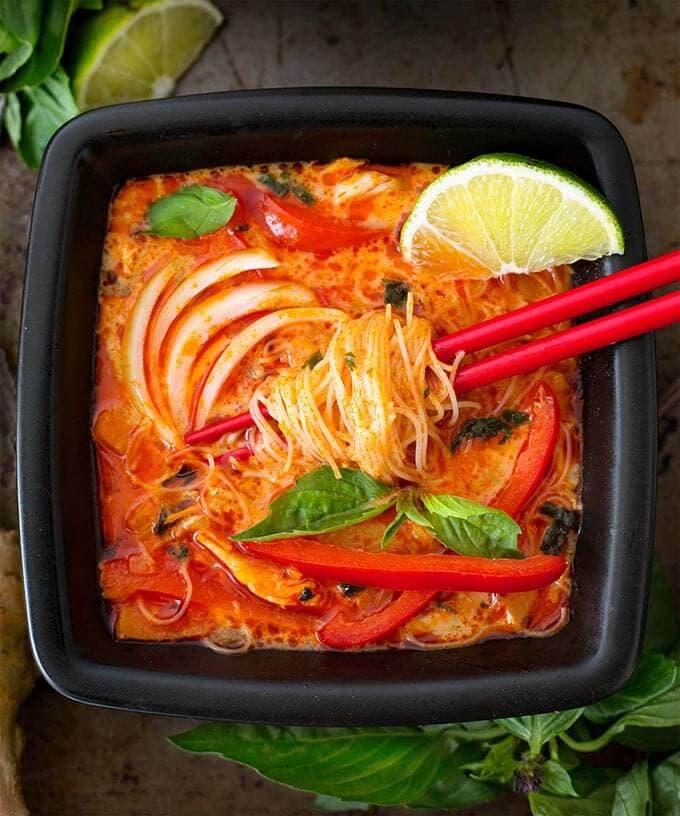 Coconut Red Curry Noodle Soup in black square bowl with red chopsticks