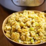 Instant Pot Cornbread Stuffing in a beige bowl with pressure cooker in background