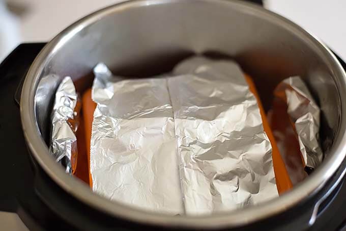 Cornbread Squares covered in aluminum foil in pot of pressure cooker