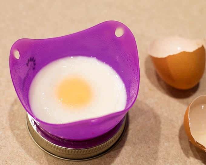 Cooked egg in small silicon mold with eggshell in background