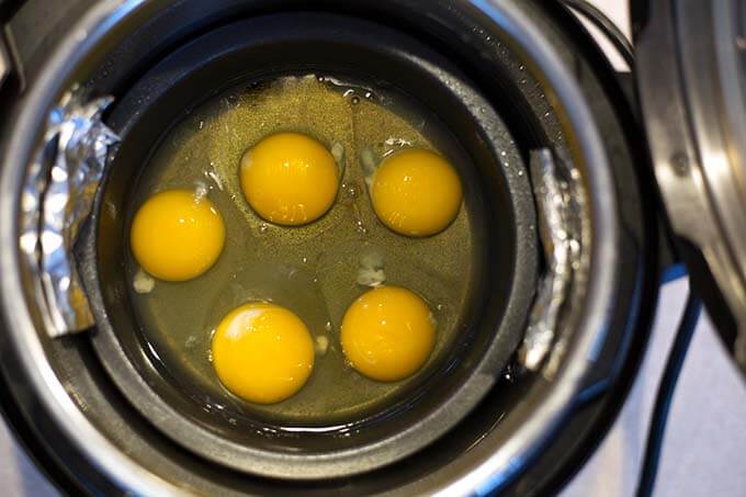 Five cracked eggs in small round pot for PIP cooking in pressure cooker