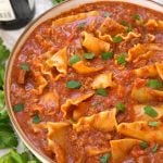 Easy Lasagna Soup in a white bowl with brown rim surrounded by parsley