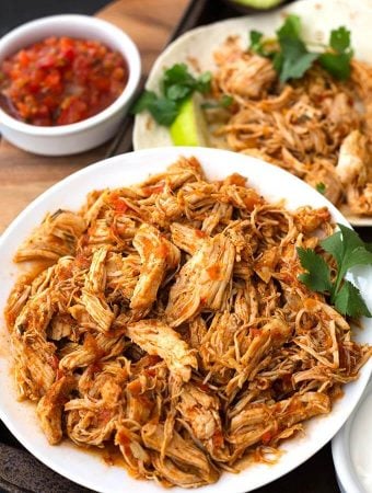 Instant Pot Salsa Chicken is Mexican flavored shredded chicken breast that you can use for tacos, burrito bowls, and casseroles. Lots of flavor, and this pressure cooker shredded chicken is so useful! simplyhappyfoodie.com #instantpotrecipes #instantpotsalsachicken #instantpotshreddedchicken #Instantpotchickenbreast #pressurecookerchicken