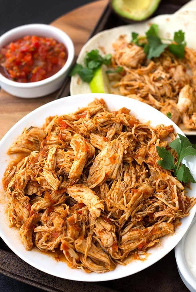 Salsa Chicken on a white plate in front of a tortilla with chicken