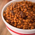 Smoky Sweet Baked Beans in a white bowl on wooden board