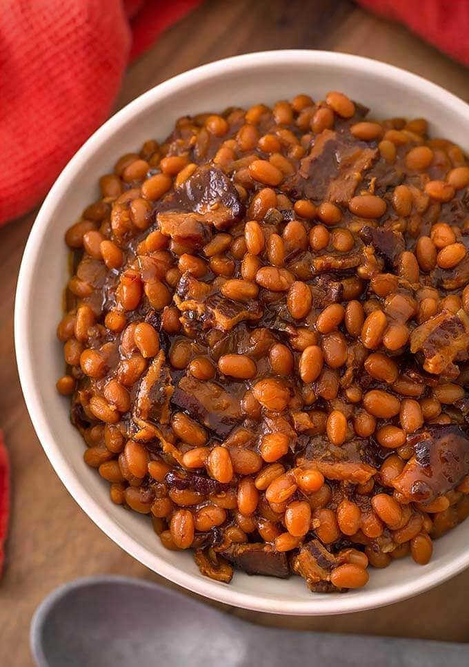 Smoky Sweet Baked Beans in a white bowl on wooden board