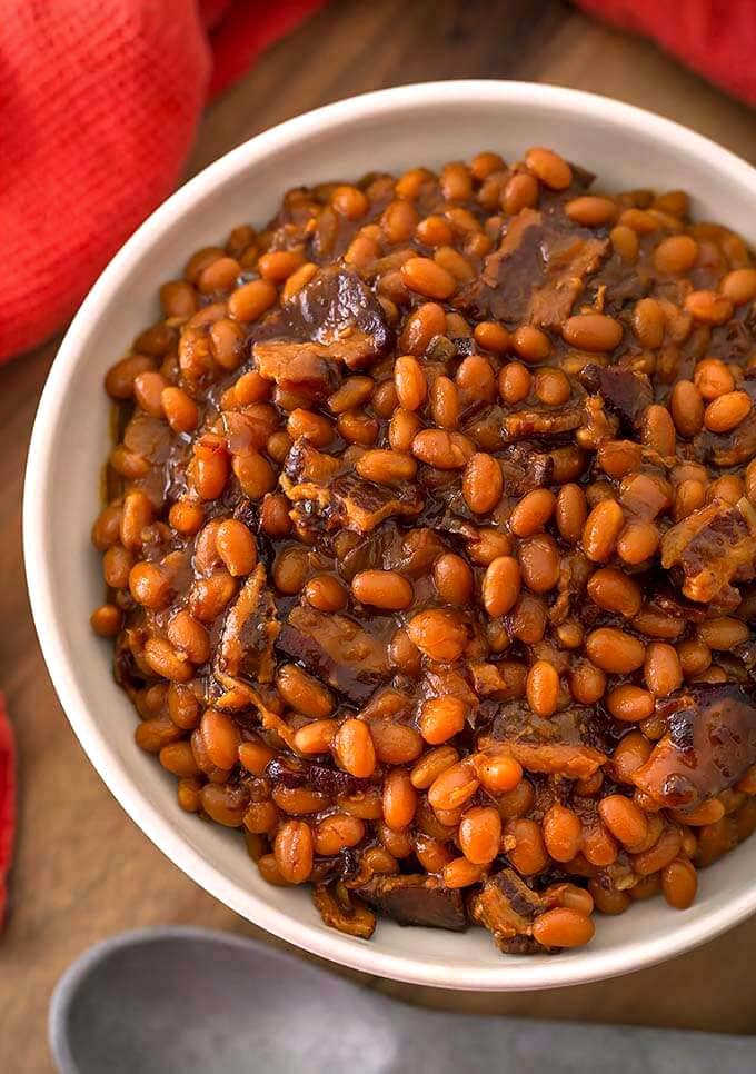 Baked Beans in a white bowl on wooden board
