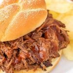 Barbecue Beef on a hamburger but with potato chips on a white plate