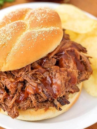 Barbecue Beef on a hamburger but with potato chips on a white plate