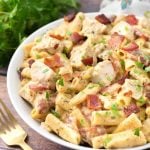 Chicken Bacon Ranch Pasta in a white bowl on wooden background with golden spoon