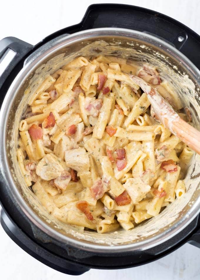 Chicken Bacon Ranch Pasta in pressure cooker with wooden spoon