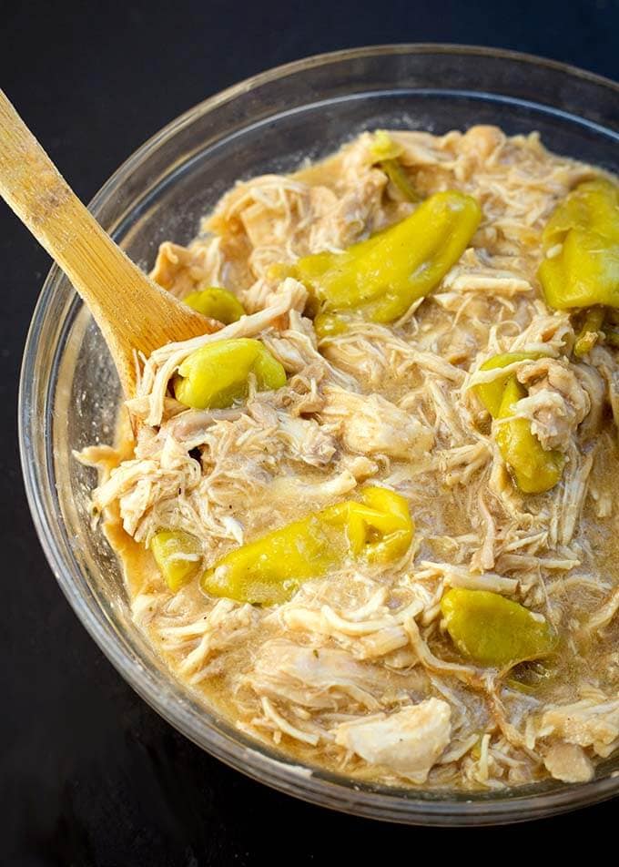 Mississippi Chicken in a glass bowl with wooden stirring spoon