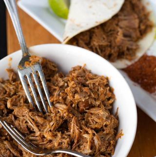 Instant Pot Pulled Pork is flavorful and very tender pork shoulder that you can shred for sandwiches, tacos, over rice or potatoes. Pressure cooker pulled pork. simplyhappyfoodie.com #instantpotpulledpork #pressurecookerpulledpork #instantpotrecipes #pressurecookerrecipes