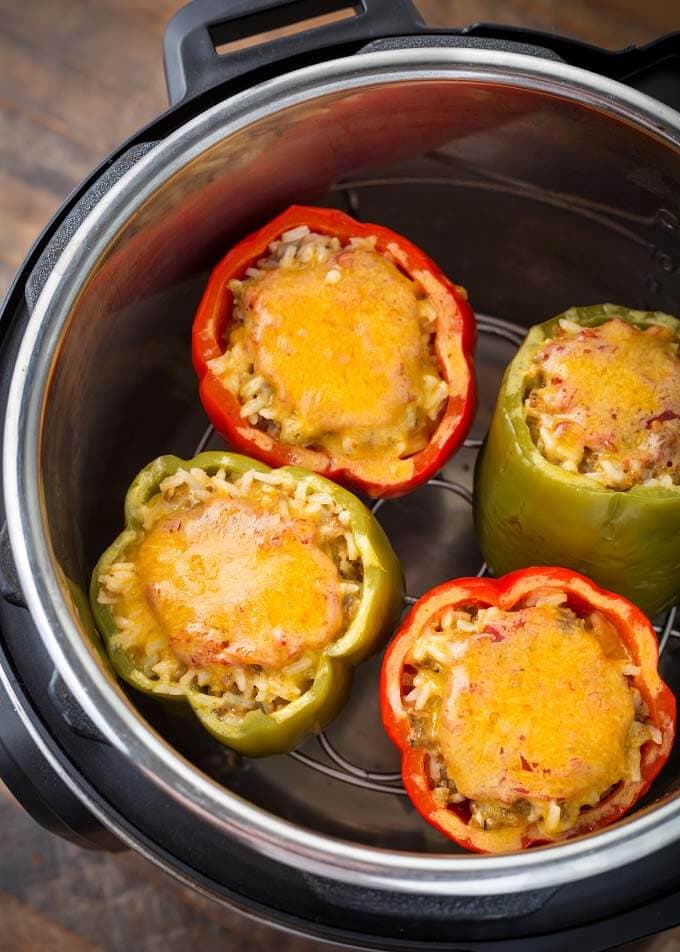 Four stuffed peppers on a trivet in pressure cooker