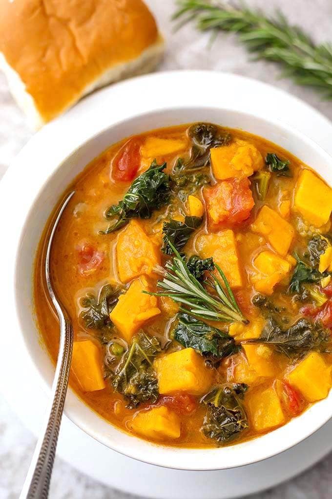 Sweet Potato Kale Soup in a white bowl with spoon