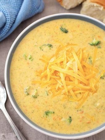 Broccoli Cheddar Soup in a gray bowl and spoon on wooden background