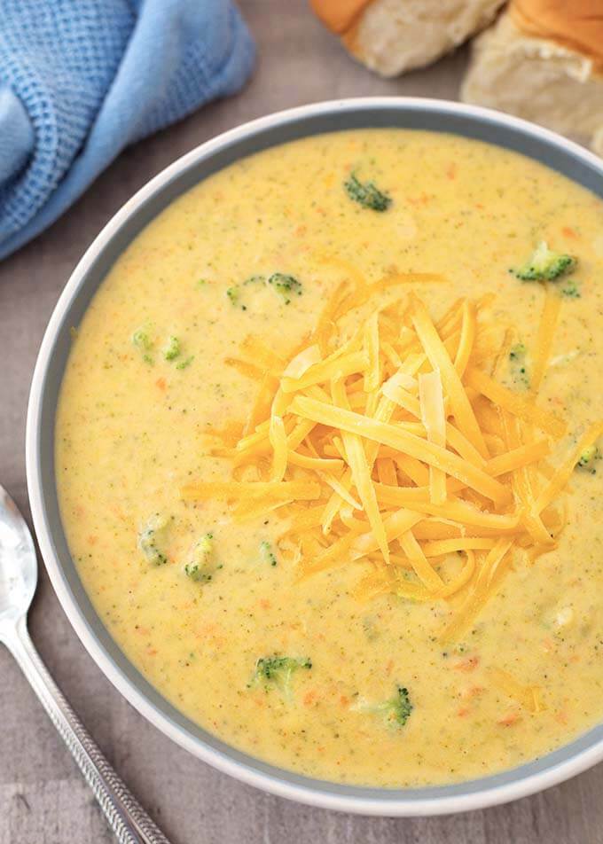 Broccoli Cheddar Soup in a gray bowl and spoon on wooden background