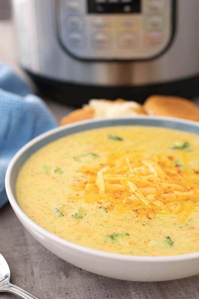 Instant Pot Broccoli Cheddar Soup in a white bowl in front of IP