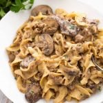 Hamburger Stroganoff on a white plate with fork next to bunch of parsley