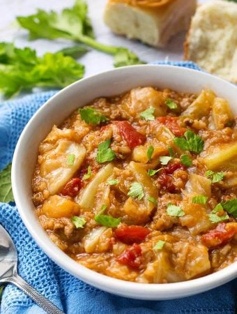 Unstuffed Cabbage Rolls in white bowl and spoon on blue kitchen towel