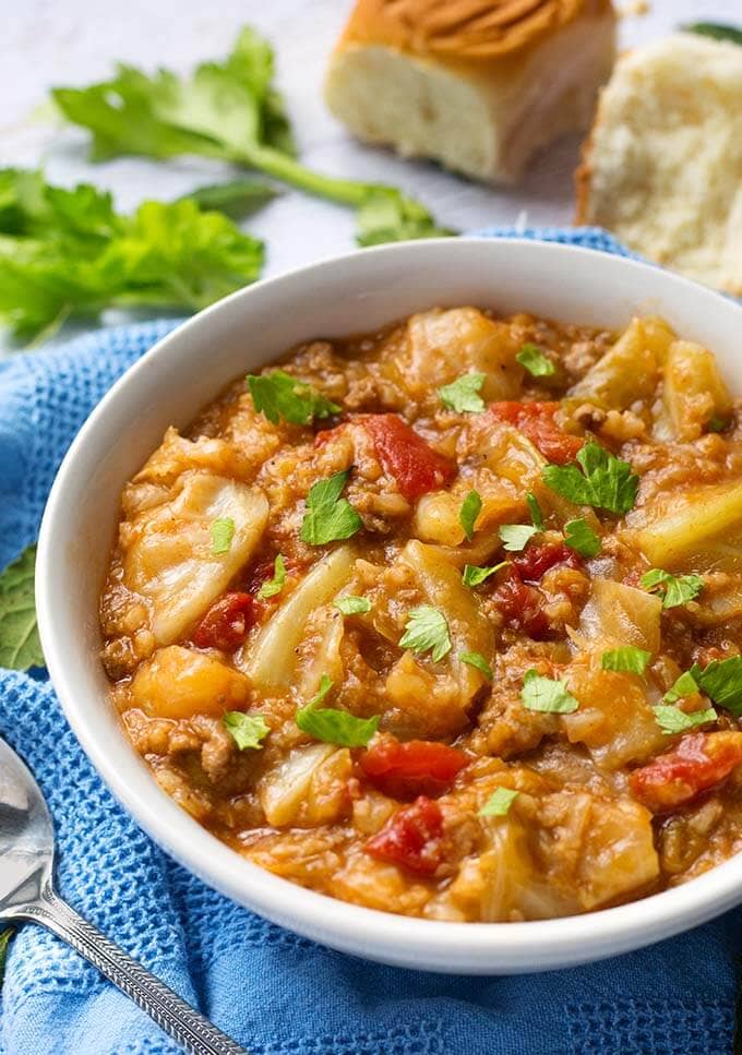 Unstuffed Cabbage Rolls in white bowl and spoon on blue kitchen towel