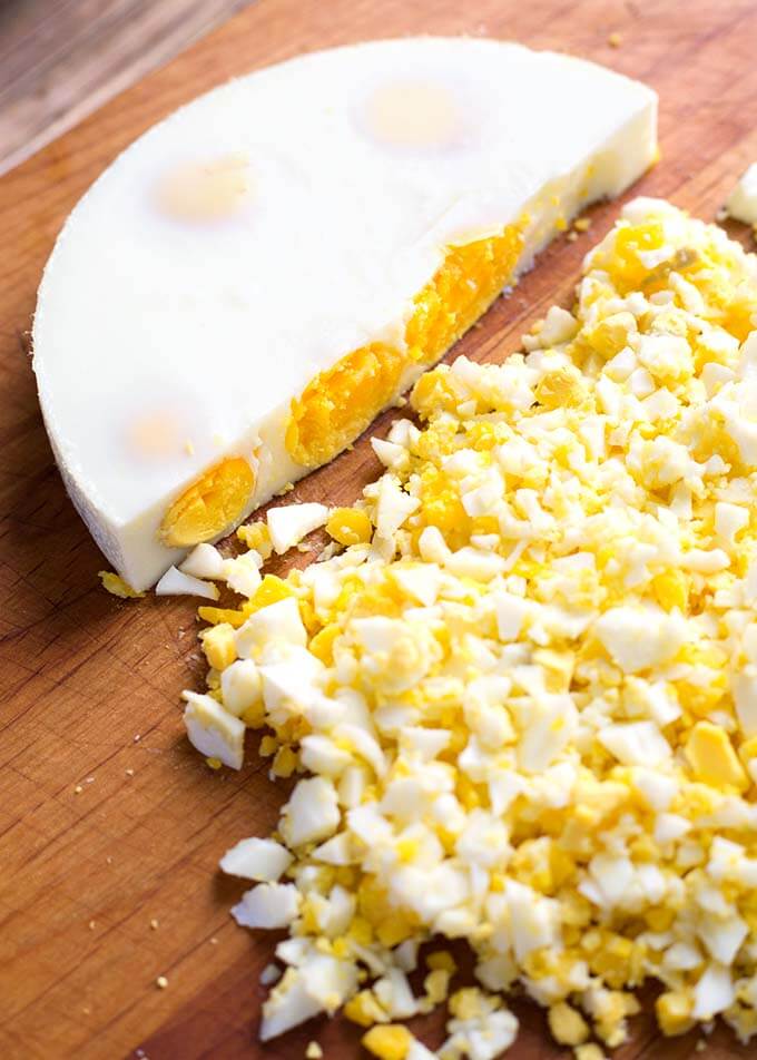 Egg Loaf on a wooden cutting board with half of loaf crumbled