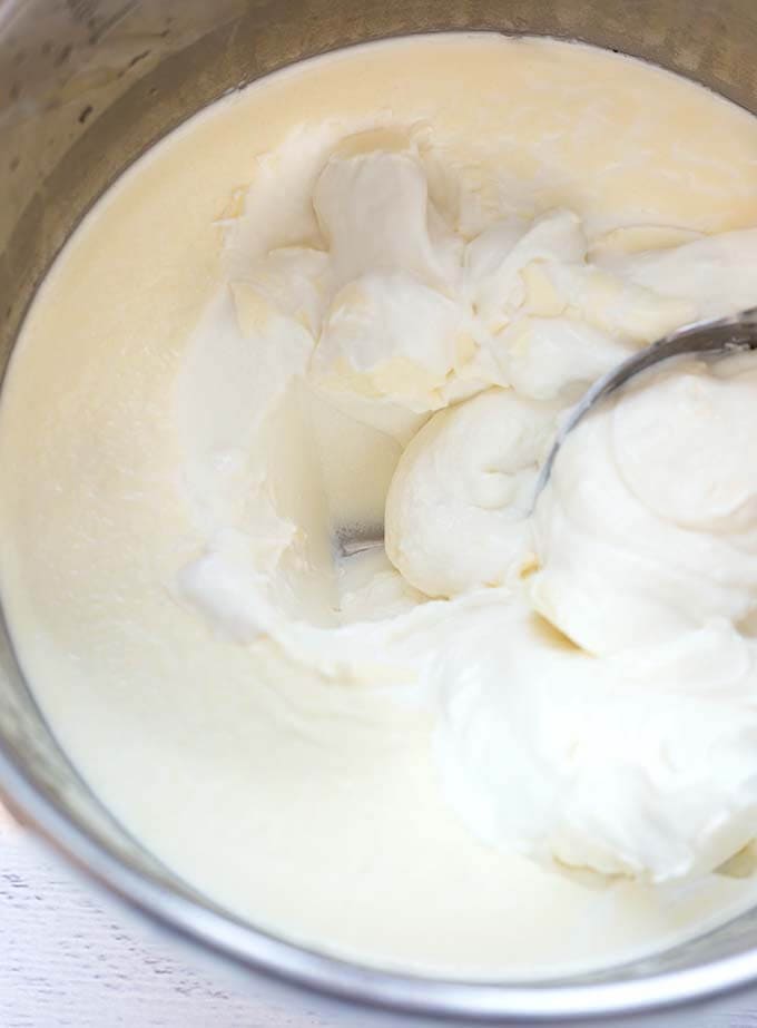 Spoon scooping yogurt in pressure cooker pot