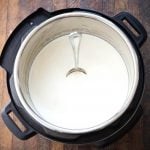 Yogurt in pressure cooker with spoon standing straight in yogurt