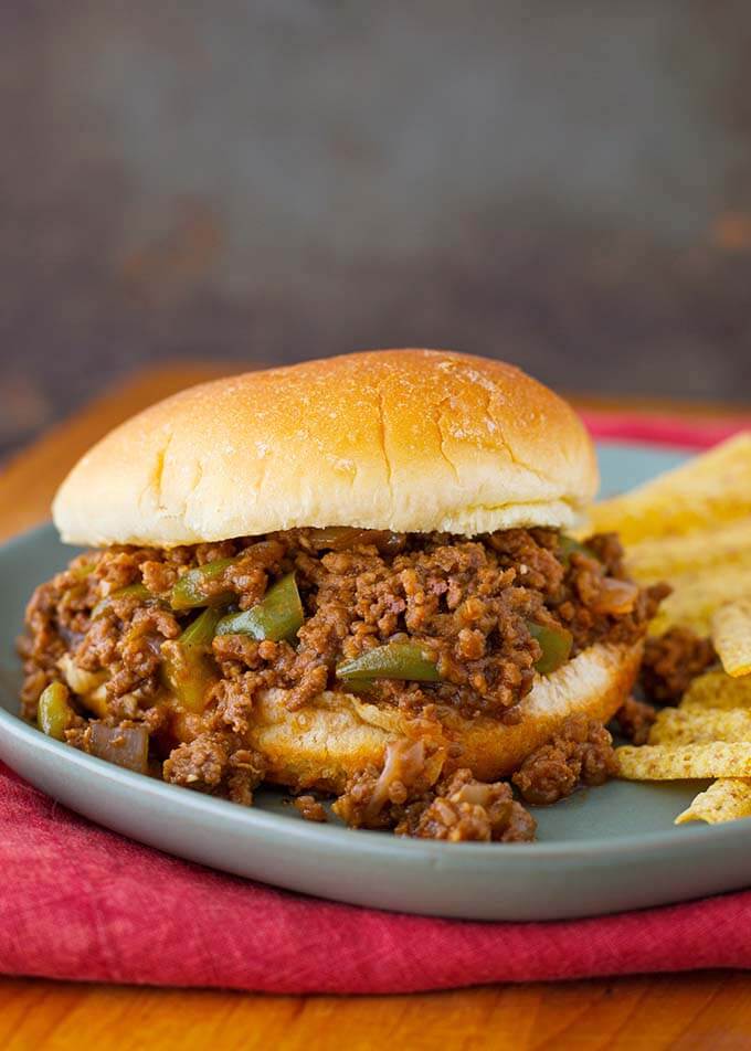 Sloppy Joe sandwich on blue plate with chips