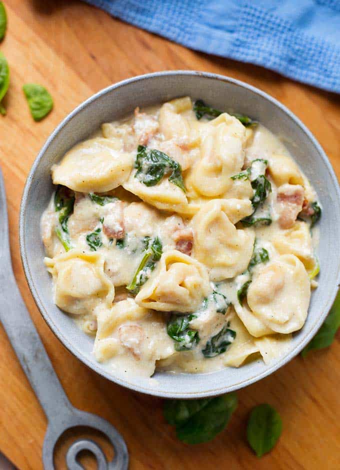 pressure cooker Tortellini Alfredo in grey bowl on wooden board