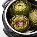 three Whole Steamed Artichokes in a pressure cooker