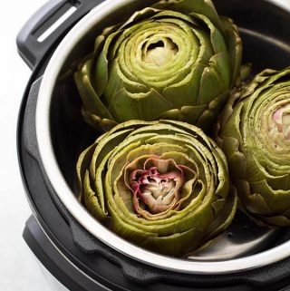 Instant Pot Whole Steamed Artichokes are a faster and easier way to cook artichokes. Pressure cooker artichokes are tender and ready to dip in your favorite sauce! simplyhappyfoodie.com #instantpotrecipes #instantpotartichokes #instantpotsteamedartichokes #instantpotwholeartichoke #pressurecookerartichoke #steamedartichokes
