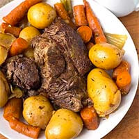 Simple Pot Roast with carrots and potatoes on a white plate