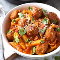 Instant Pot Meatball Pasta Dinner in a white bowl next to a silver fork