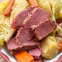 Corned Beef and Cabbage on a white and red plate