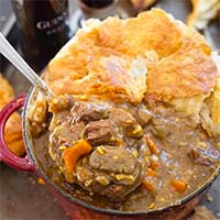 Beef Guinness Stew in a black rimmed bowl with a spoon