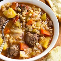 Instant Pot Beef Barley Vegetable Soup in a white bowl with a spoon