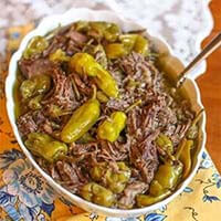 Pepperoncini Italian Beef (4 ingredients) in a white bowl with a spoon on a floral background