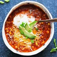 Delicious Instant Pot Chili in a white bowl with a spoon